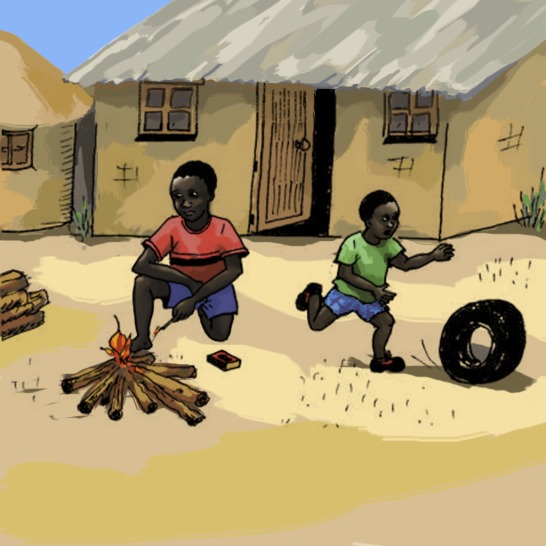 A boy sitting in front of a campfire and a boy running after a tyre.
